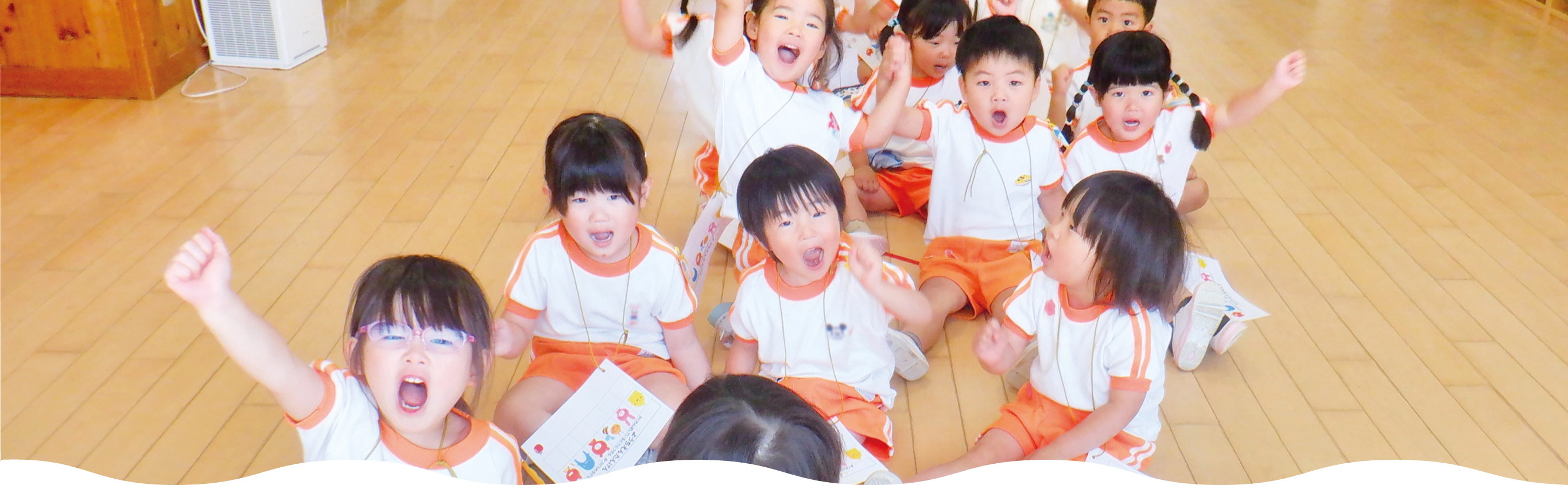 講堂で手をあげる園児たち