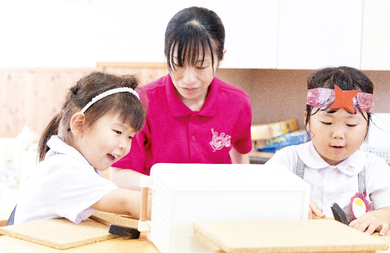 預かり保育で絵を描く女児