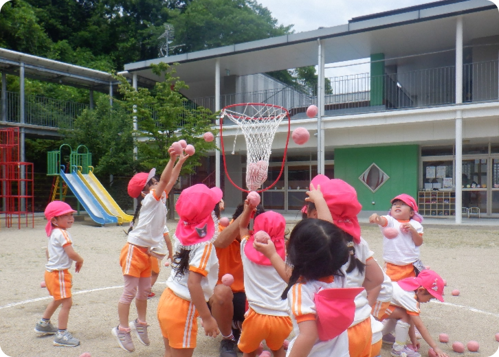 園庭で玉入れする園児たち