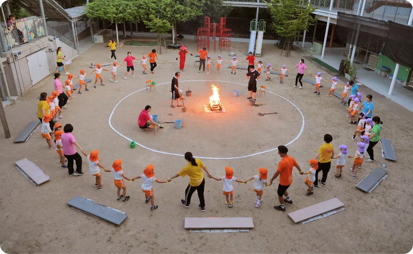 園庭でキャンプファイヤーをする園児たち